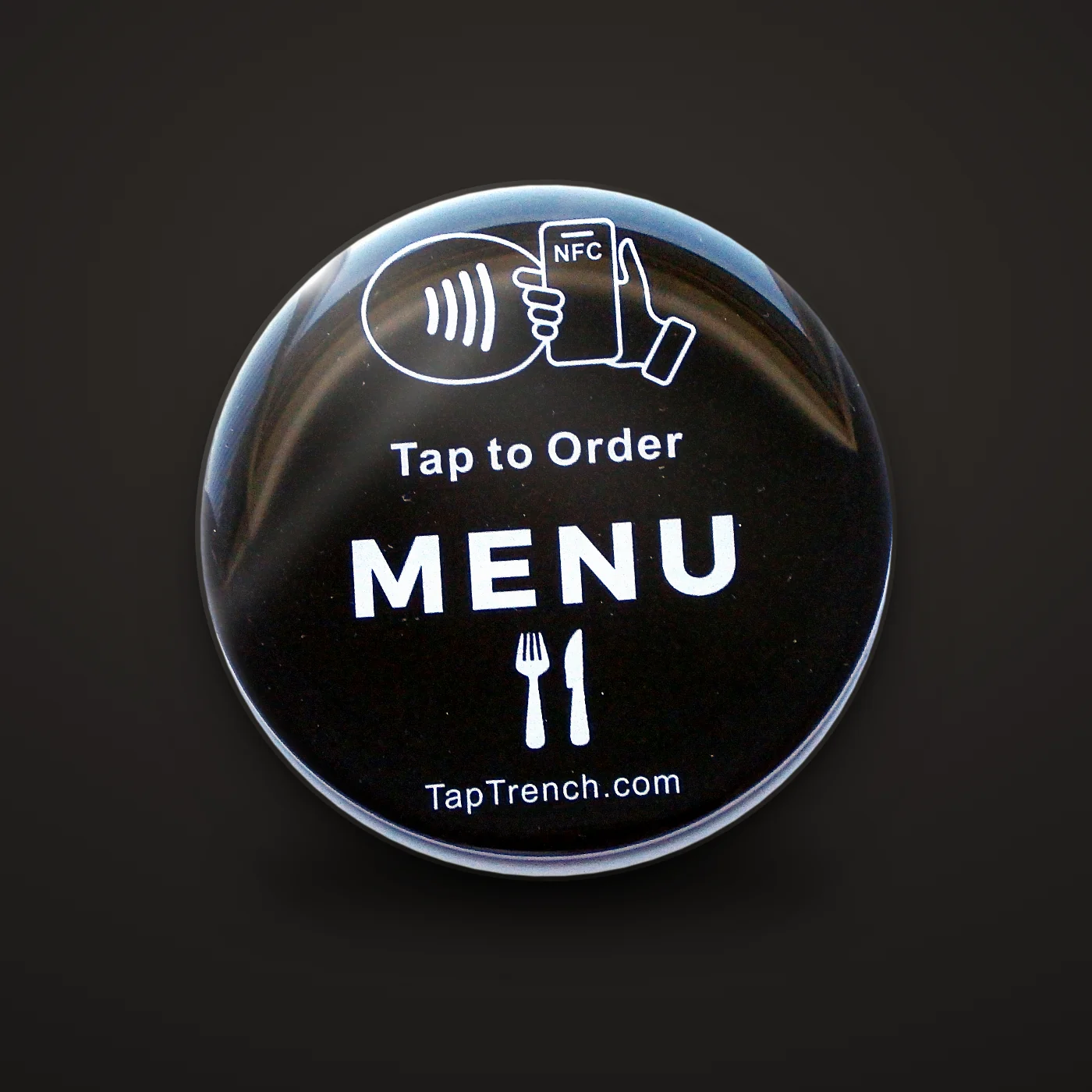 Round menu tap plate close-up on a dark background